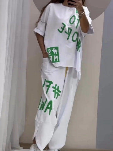 Harf desenli, yuvarlak yakalı ve yırtmaçlı cepli bir elbise